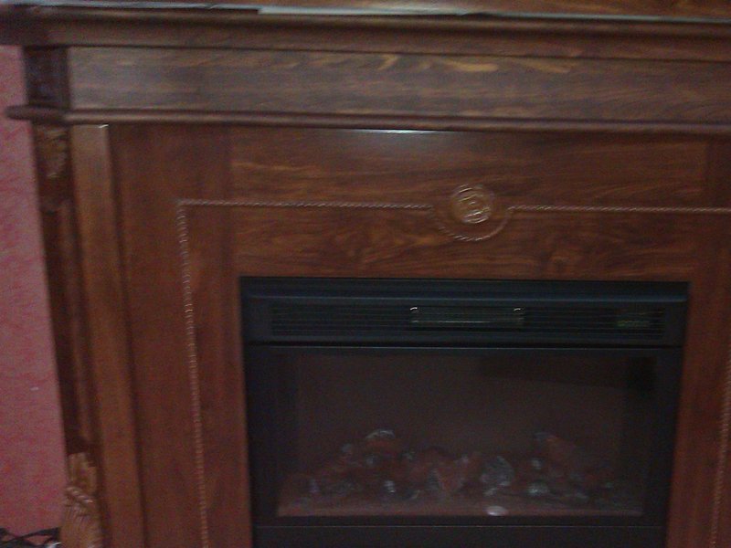 Victorian-style dark wood fireplace mantel, hand-carved
